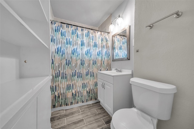 6423 Fisher Rd, Dallas, TX 75214 - full bath with toilet, vanity, curtained shower, and wood finished floors