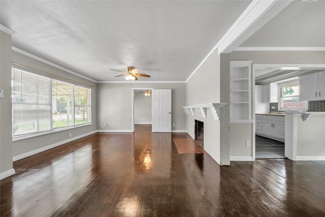 6423 Fisher Rd, Dallas, TX 75214 - unfurnished living room with ceiling fan, a brick fireplace, ornamental molding, dark wood-style floors, and a sink