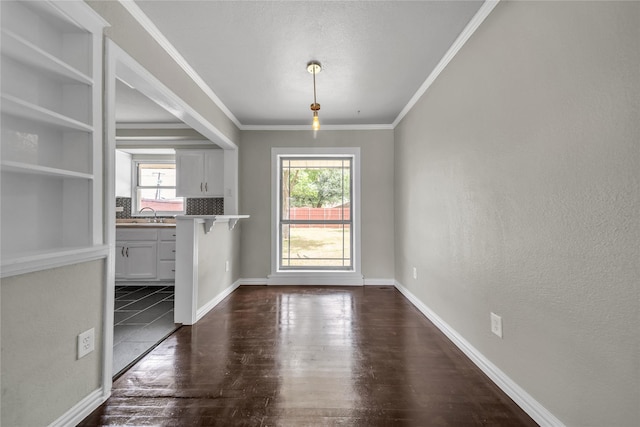6423 Fisher Rd, Dallas, TX 75214 - unfurnished dining area with dark wood finished floors, a sink, ornamental molding, and baseboards