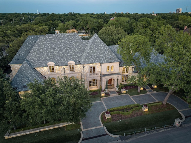 9996 Hollow Way Rd, Dallas, TX 75220 - view of front of property featuring a balcony, stone siding, a high end roof, uncovered parking, and a wooded view