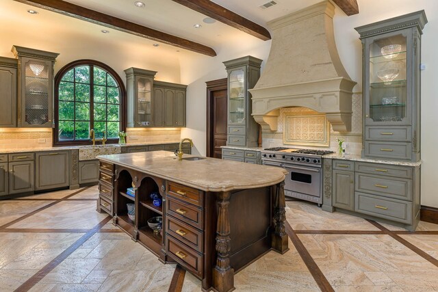 9996 Hollow Way Rd, Dallas, TX 75220 - kitchen with high end stainless steel range, a sink, inlaid floor details, beam ceiling, and stone tile flooring