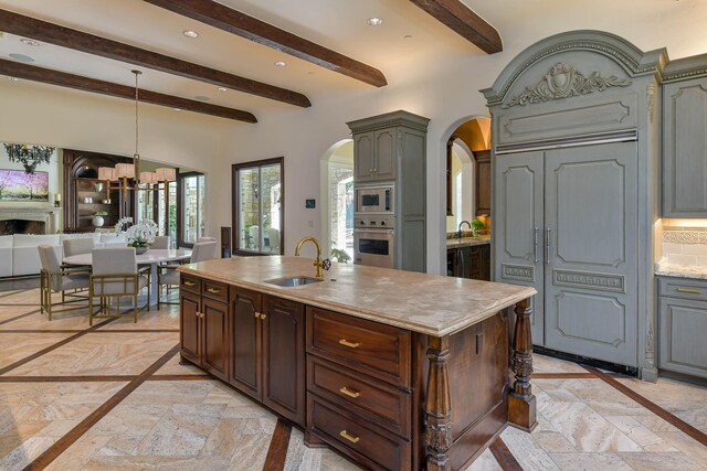9996 Hollow Way Rd, Dallas, TX 75220 - kitchen with stainless steel appliances, arched walkways, a sink, inlaid floor details, and beamed ceiling