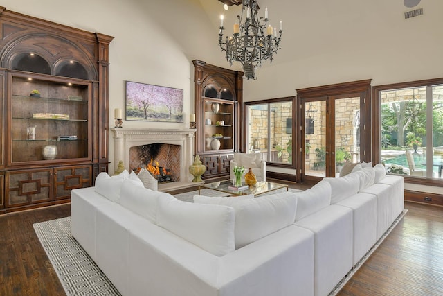 9996 Hollow Way Rd, Dallas, TX 75220 - living area with a chandelier, dark wood-style flooring, a warm lit fireplace, and a towering ceiling