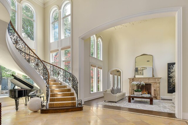 9996 Hollow Way Rd, Dallas, TX 75220 - entryway featuring a towering ceiling, plenty of natural light, stairs, baseboards, and crown molding