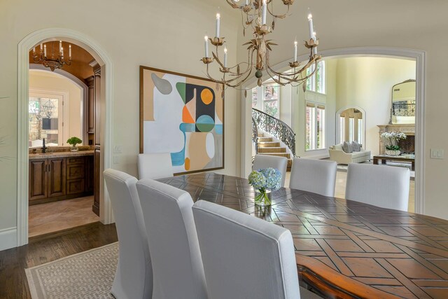 9996 Hollow Way Rd, Dallas, TX 75220 - dining space with a chandelier, arched walkways, dark wood finished floors, and stairs