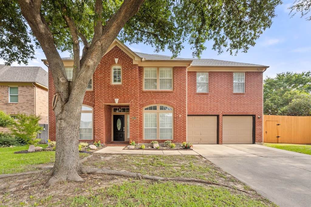 6952 Canyon Springs Rd, Fort Worth, TX 76132 - colonial-style house featuring a garage, concrete driveway, and brick siding