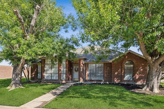 226 E Ridgegate Dr, Garland, TX 75040 - view of front of home with brick siding, a front yard, and a shingled roof