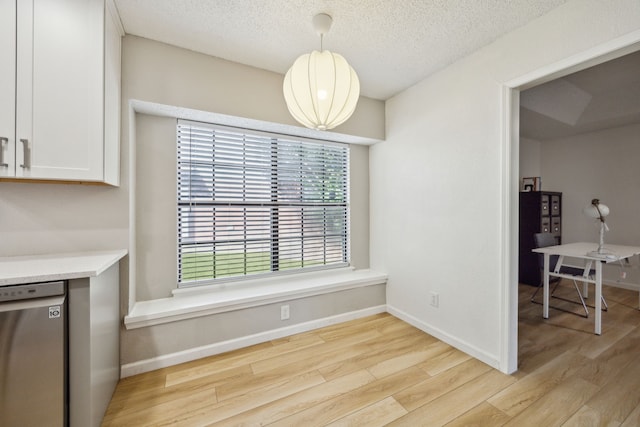 226 E Ridgegate Dr, Garland, TX 75040 - unfurnished dining area featuring light wood-style flooring, healthy amount of natural light, baseboards, and a textured ceiling