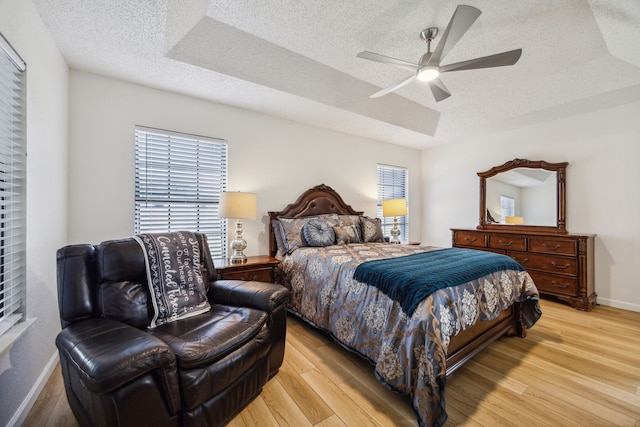 226 E Ridgegate Dr, Garland, TX 75040 - bedroom with a textured ceiling, baseboards, light wood-style floors, and multiple windows