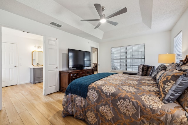 226 E Ridgegate Dr, Garland, TX 75040 - bedroom featuring a tray ceiling, light wood-style flooring, a ceiling fan, and baseboards