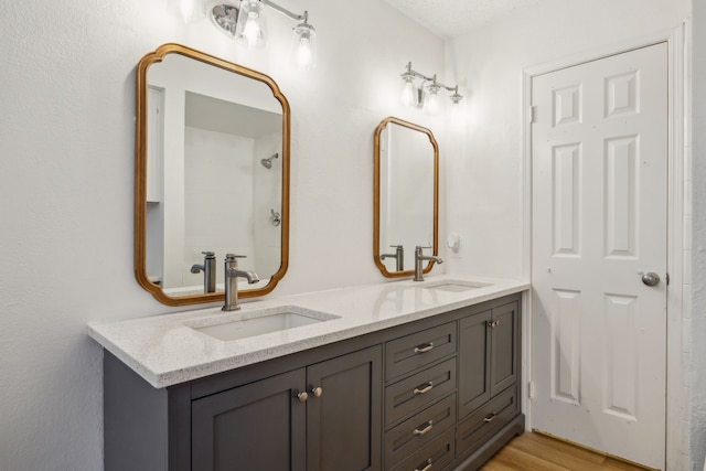 226 E Ridgegate Dr, Garland, TX 75040 - bathroom featuring double vanity and wood finished floors
