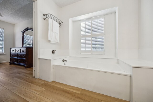 226 E Ridgegate Dr, Garland, TX 75040 - full bath featuring a garden tub and wood finished floors