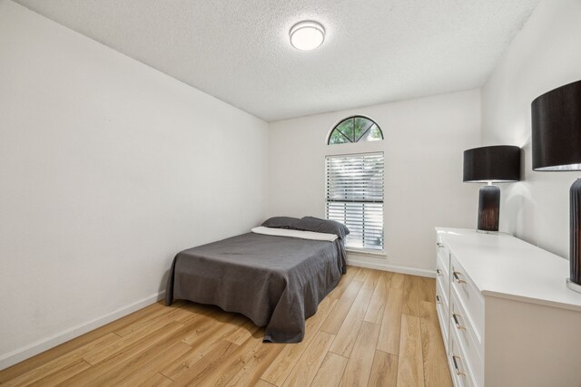 226 E Ridgegate Dr, Garland, TX 75040 - bedroom with a textured ceiling, light wood-style flooring, and baseboards