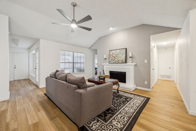 226 E Ridgegate Dr, Garland, TX 75040 - living area featuring lofted ceiling, ceiling fan, a fireplace, light wood-style flooring, and baseboards