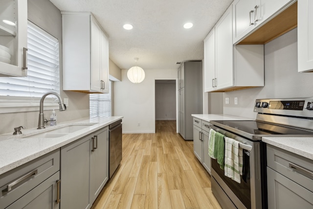 226 E Ridgegate Dr, Garland, TX 75040 - kitchen featuring stainless steel appliances, a sink, gray cabinetry, light wood-style floors, and recessed lighting