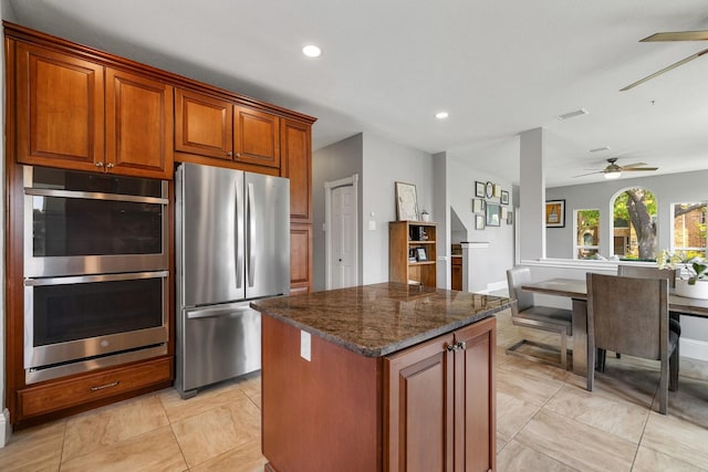 6821 Rochelle Dr, Plano, TX 75023 - kitchen featuring stainless steel appliances, a ceiling fan, dark stone counters, a center island, and recessed lighting
