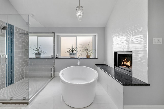 6821 Rochelle Dr, Plano, TX 75023 - bathroom with a shower stall, a freestanding tub, a fireplace, vaulted ceiling, and marble finish flooring