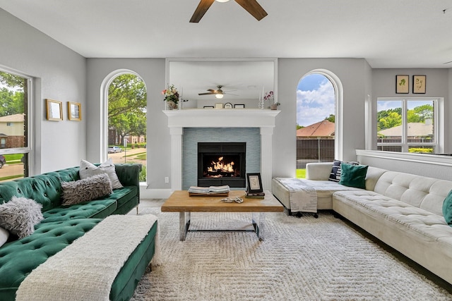 6821 Rochelle Dr, Plano, TX 75023 - living area featuring ceiling fan, wood finished floors, a warm lit fireplace, and plenty of natural light