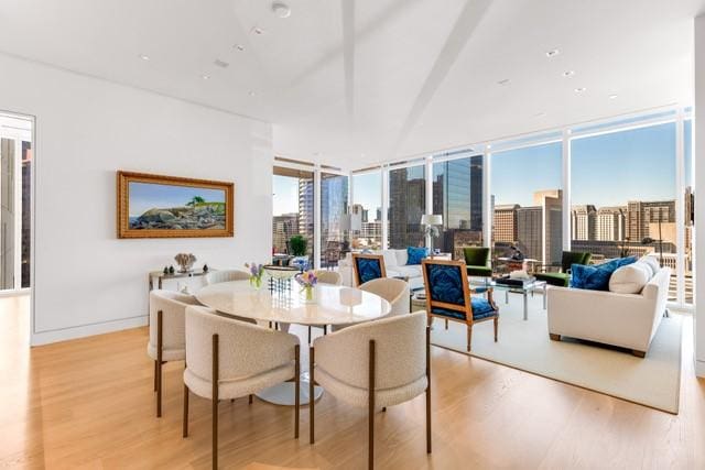 1747 Leonard St Unit 903, Dallas, TX 75201 - dining space featuring light wood finished floors, floor to ceiling windows, and a view of skyline