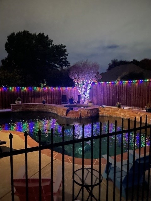 6712 E Park Dr, Fort Worth, TX 76132 - pool at night featuring a pool with connected hot tub