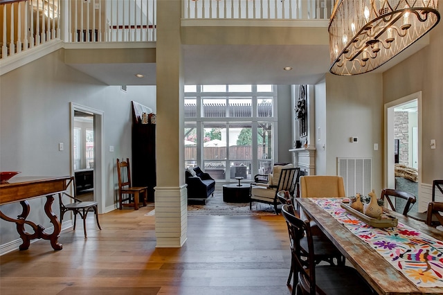 6712 E Park Dr, Fort Worth, TX 76132 - dining space featuring a high ceiling, plenty of natural light, wood finished floors, ornate columns, and baseboards