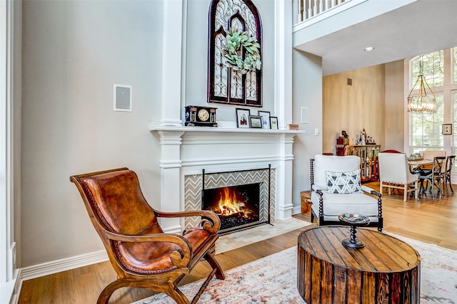 6712 E Park Dr, Fort Worth, TX 76132 - sitting room with a chandelier, a fireplace with flush hearth, wood finished floors, and baseboards