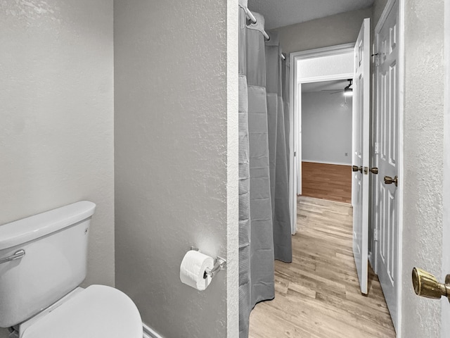 539 Mel Ct, Euless, TX 76039 - bathroom featuring wood finished floors, toilet, and a textured wall