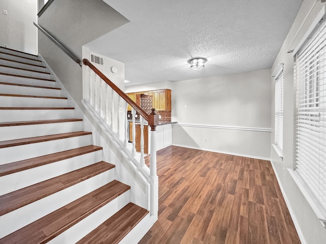 539 Mel Ct, Euless, TX 76039 - staircase featuring baseboards, wood finished floors, and a textured ceiling