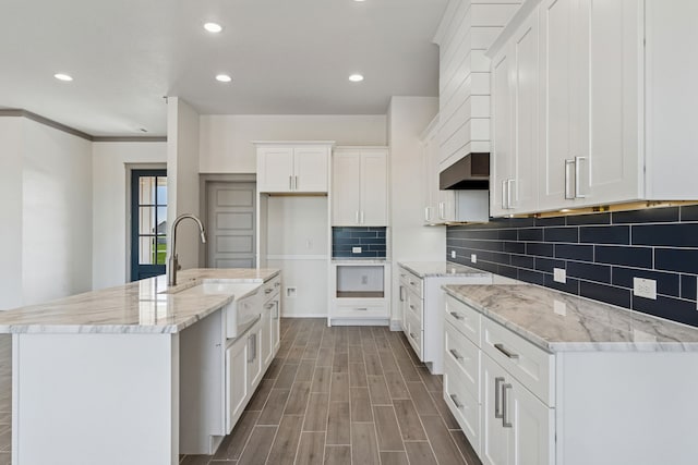 106 Maverick Way, Boyd, TX 76023 - kitchen with a sink, recessed lighting, decorative backsplash, light stone countertops, and white cabinetry