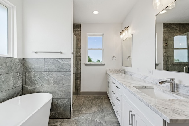 106 Maverick Way, Boyd, TX 76023 - bathroom featuring double vanity, a freestanding tub, marble finish floors, a stall shower, and tile walls