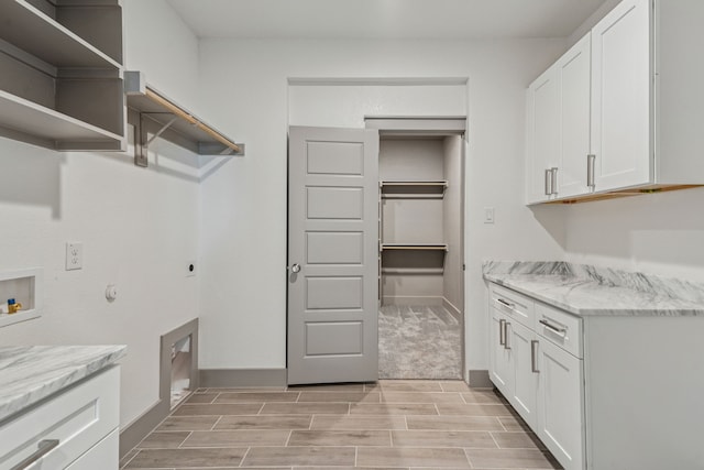106 Maverick Way, Boyd, TX 76023 - washroom featuring cabinet space, electric dryer hookup, wood tiled floors, baseboards, and gas dryer hookup