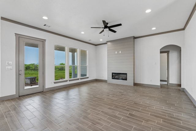106 Maverick Way, Boyd, TX 76023 - unfurnished living room featuring a ceiling fan, ornamental molding, baseboards, arched walkways, and light wood finished floors