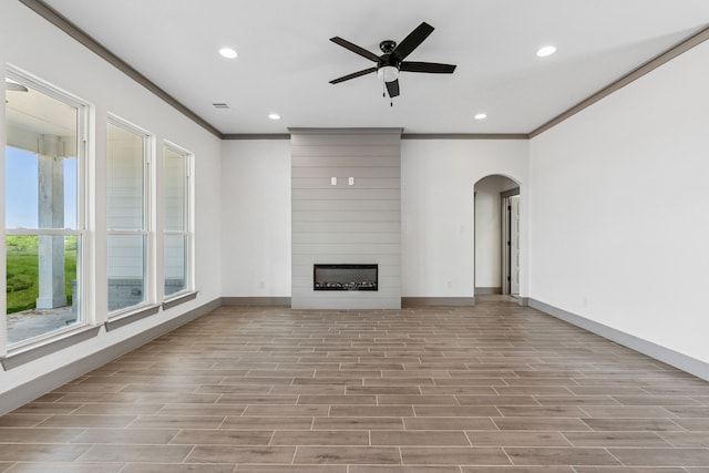 106 Maverick Way, Boyd, TX 76023 - unfurnished living room featuring crown molding, arched walkways, recessed lighting, baseboards, and a ceiling fan