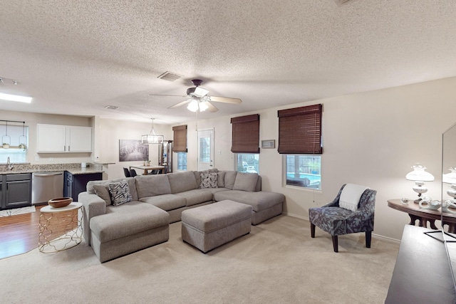 1211 Leeward Ln, Wylie, TX 75098 - living area featuring light carpet, ceiling fan, a textured ceiling, and baseboards