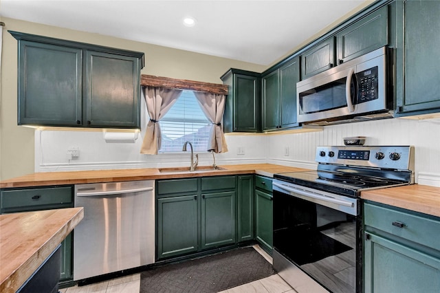 4318 Quail Run Rd, Sherman, TX 75092 - kitchen featuring butcher block countertops, appliances with stainless steel finishes, a sink, green cabinets, and recessed lighting