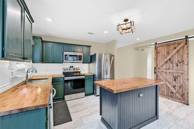 4318 Quail Run Rd, Sherman, TX 75092 - kitchen with butcher block countertops, stainless steel appliances, a sink, a barn door, and recessed lighting