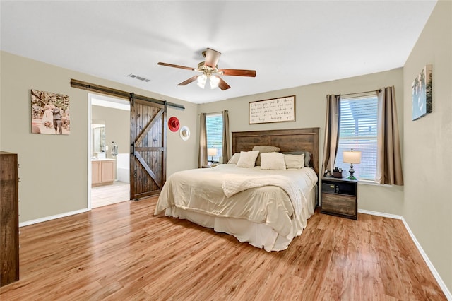 4318 Quail Run Rd, Sherman, TX 75092 - bedroom with a barn door, light wood finished floors, baseboards, and ensuite bath