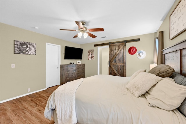 4318 Quail Run Rd, Sherman, TX 75092 - bedroom with a barn door, wood finished floors, baseboards, and ceiling fan