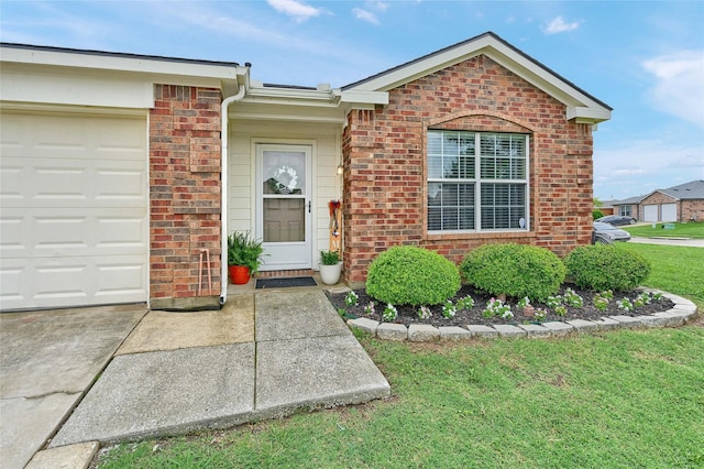 4318 Quail Run Rd, Sherman, TX 75092 - view of exterior entry featuring an attached garage, brick siding, a yard, and concrete driveway
