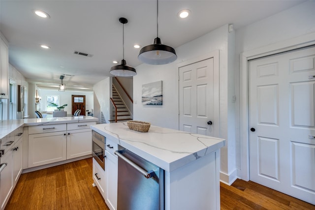 6819 Santa Fe Ave, Dallas, TX 75223 - kitchen with appliances with stainless steel finishes, wood finished floors, white cabinetry, decorative light fixtures, and recessed lighting