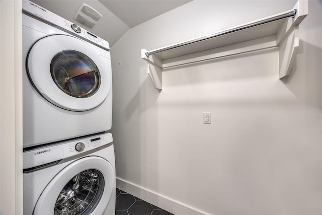 6819 Santa Fe Ave, Dallas, TX 75223 - laundry area with estacked washer and dryer, dark tile patterned flooring, and baseboards
