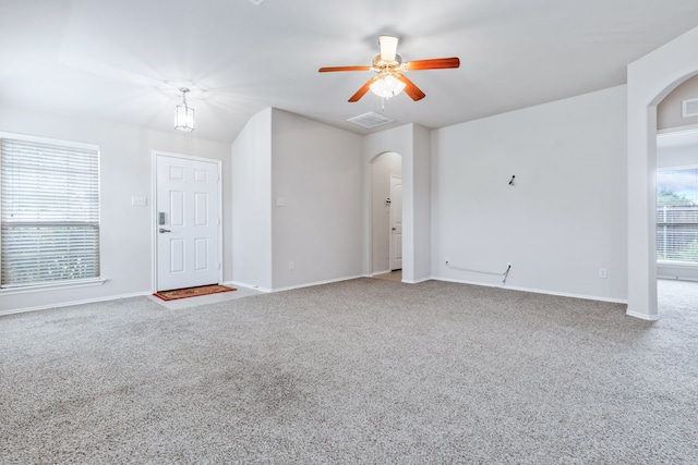 608 W Grove Cir, Anna, TX 75409 - unfurnished living room with arched walkways, carpet floors, a ceiling fan, and baseboards