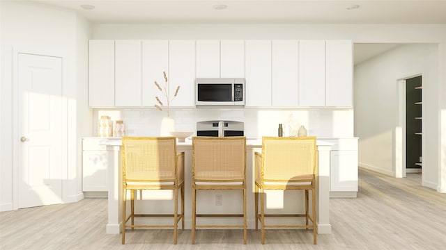 1817 Golden Sq, Cedar Hill, TX 75116 - kitchen featuring stainless steel microwave, tasteful backsplash, light wood-style flooring, and white cabinets