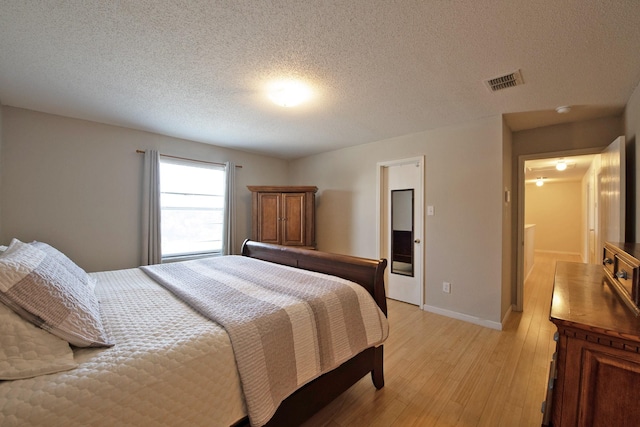 1446 Foxwood Ln, Rockwall, TX 75032 - bedroom with light wood finished floors, a textured ceiling, and baseboards