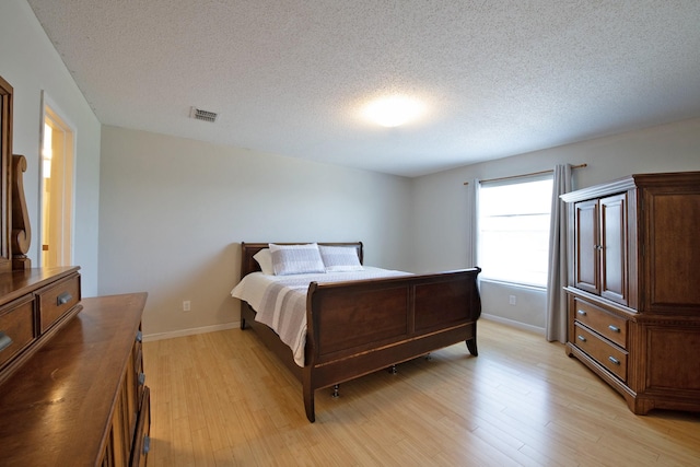 1446 Foxwood Ln, Rockwall, TX 75032 - bedroom featuring light wood-style floors, a textured ceiling, and baseboards