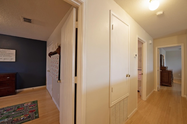 1446 Foxwood Ln, Rockwall, TX 75032 - corridor with light wood-type flooring, baseboards, and a textured ceiling