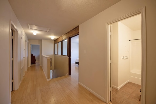 1446 Foxwood Ln, Rockwall, TX 75032 - hall featuring light wood finished floors, attic access, and baseboards