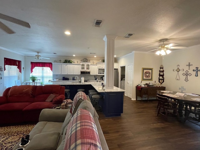 102 Dogwood Cir, Daingerfield, TX 75638 - living room featuring a ceiling fan, crown molding, dark wood-style flooring, and decorative columns