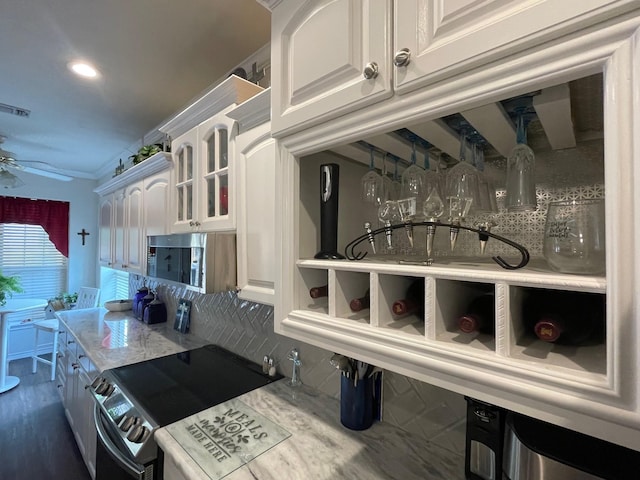 102 Dogwood Cir, Daingerfield, TX 75638 - kitchen with appliances with stainless steel finishes, decorative backsplash, white cabinets, a ceiling fan, and glass insert cabinets