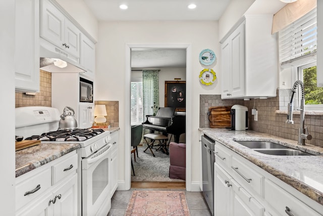 7805 Eagle Trl, Dallas, TX 75238 - kitchen with white gas range, a sink, dishwasher, under cabinet range hood, and white cabinets